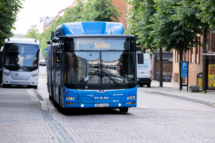 En blå buss på en kullerstensgata.